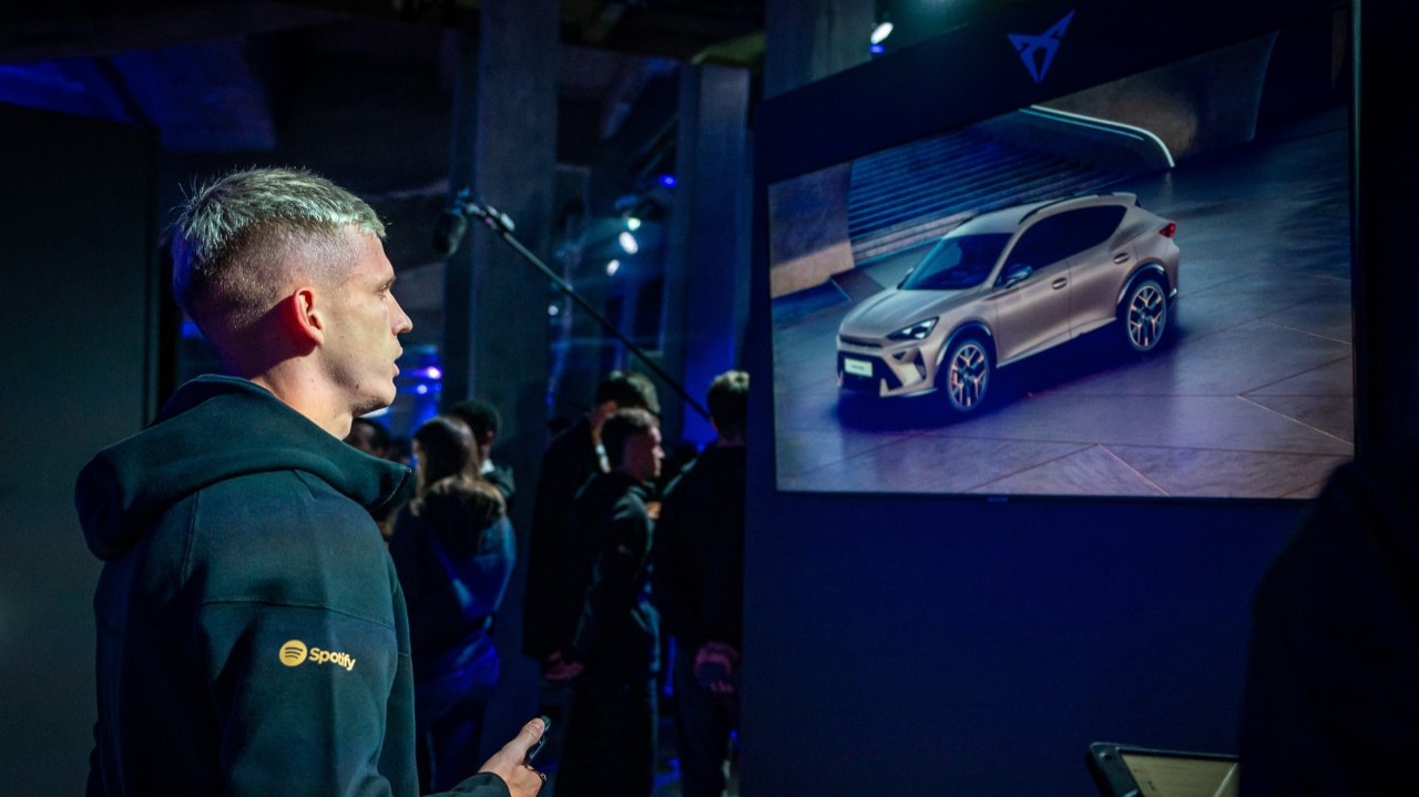 Dani Olmo mirando una pantalla que está reproduciendo imágenes de un CUPRA Formentor