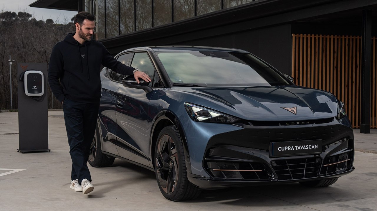 Saúl Craviotto caminando junto a su CUPRA Tavascan eléctrico