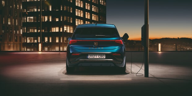 CUPRA eléctrico aparcado en un entorno moderno, resaltando su diseño aerodinámico.