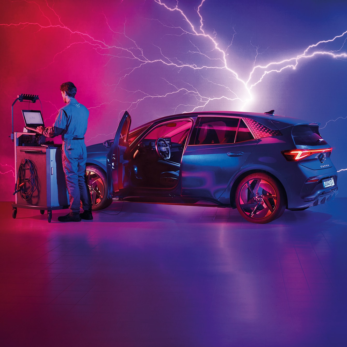 Técnico de mantenimiento revisando un CUPRA Formentor en un taller de alta tecnología con iluminación eléctrica en tonos púrpura y rosa.