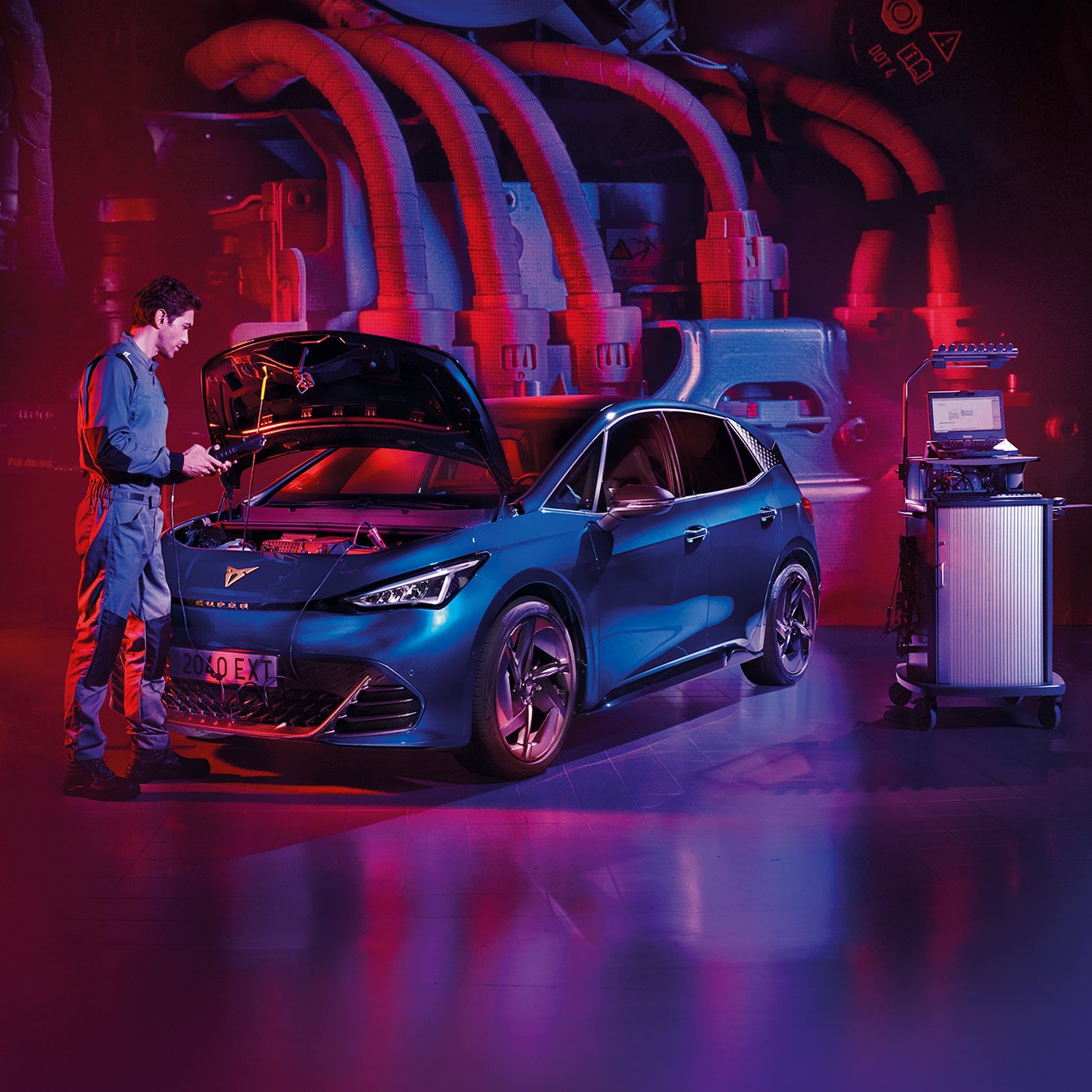 CUPRA Born en un garaje con diseño industrial futurista y luces de neón rojas y violetas, mientras un técnico inspecciona el motor del coche eléctrico.