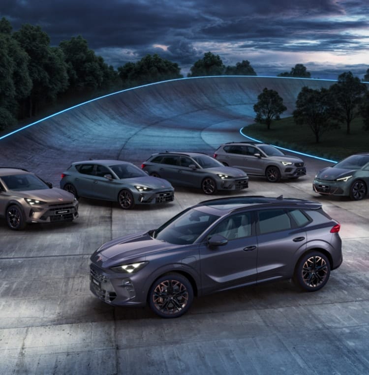 Gama de coches CUPRA alineados en un entorno natural con iluminación ambiental azul.