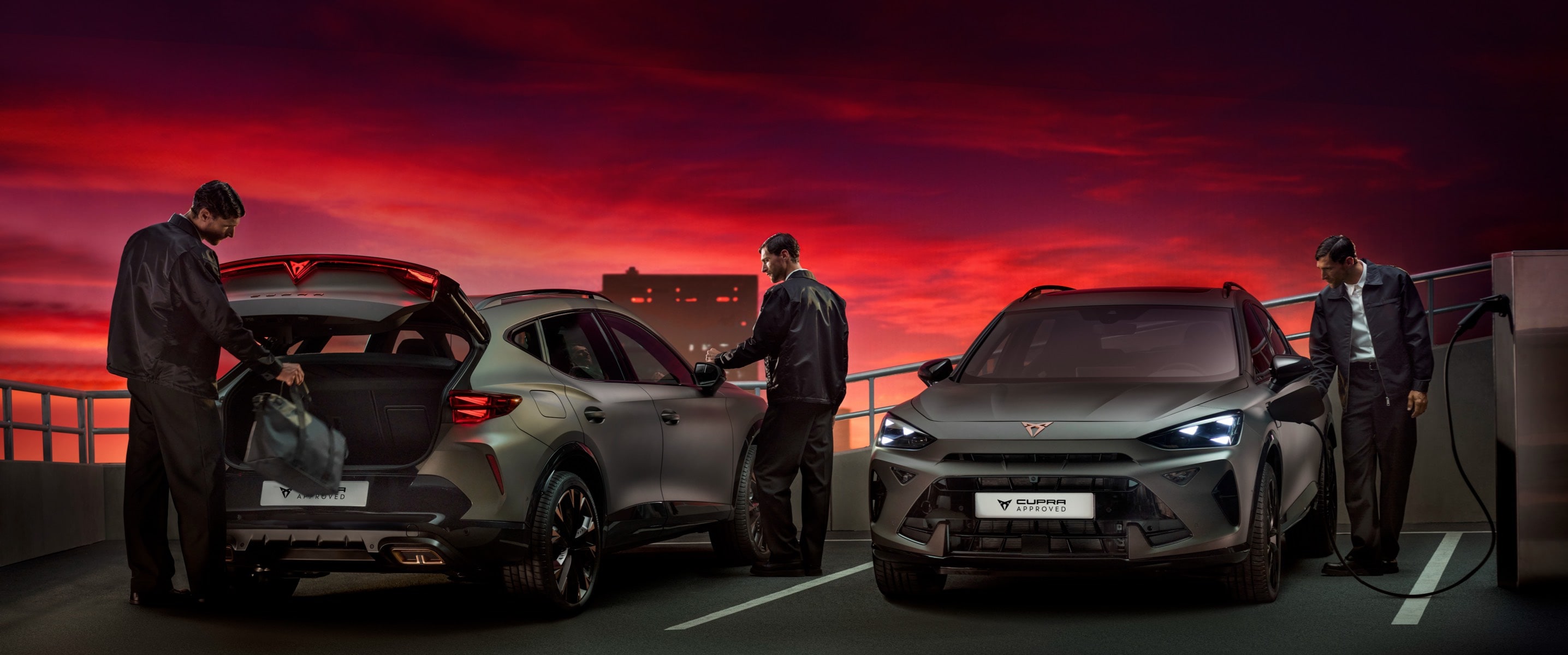 CUPRA Formentor híbrido enchufable conectado a punto de carga pública en escenario al atardecer con cielo rojo