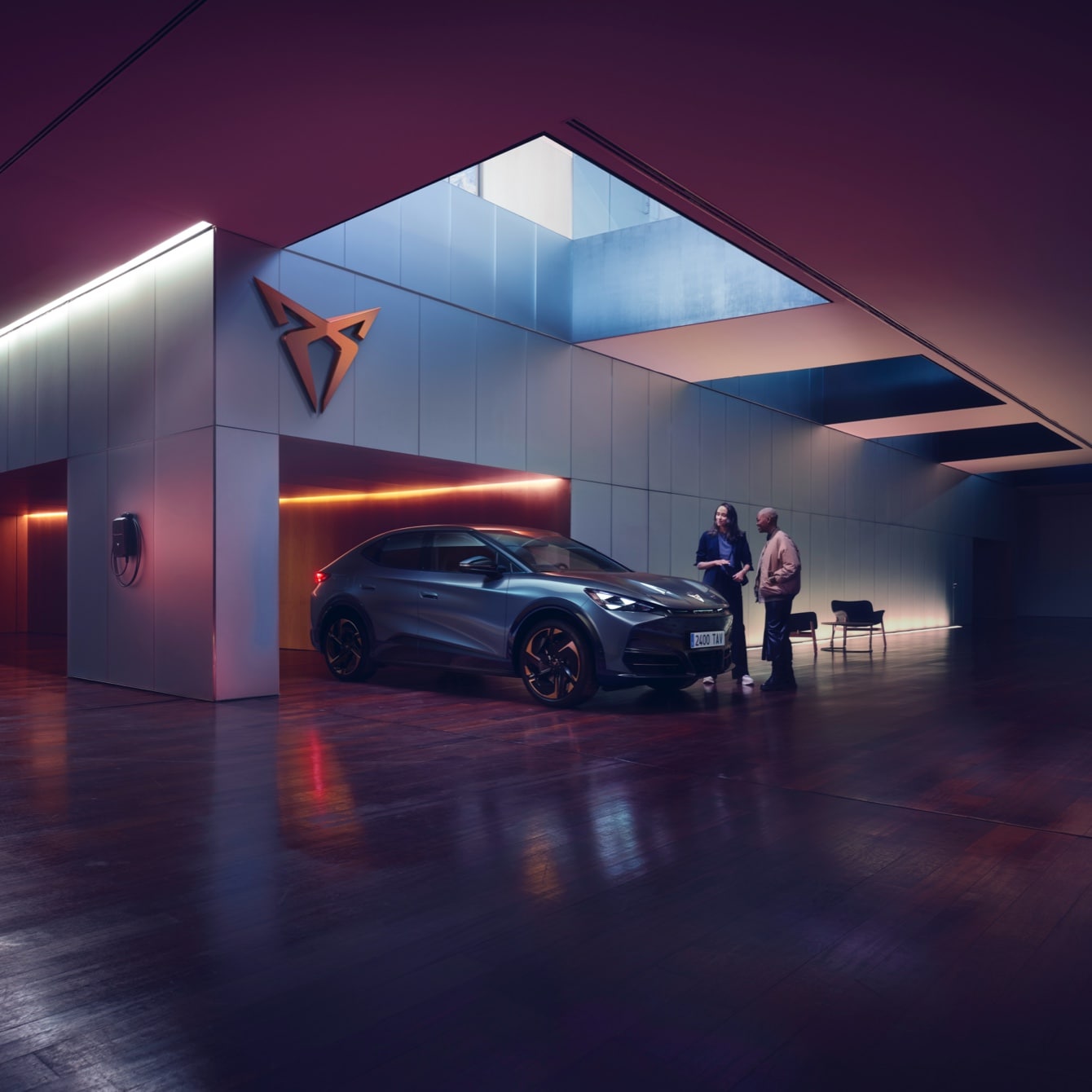 CUPRA Tavascan en un espacio de exposición moderno con iluminación ambiental púrpura