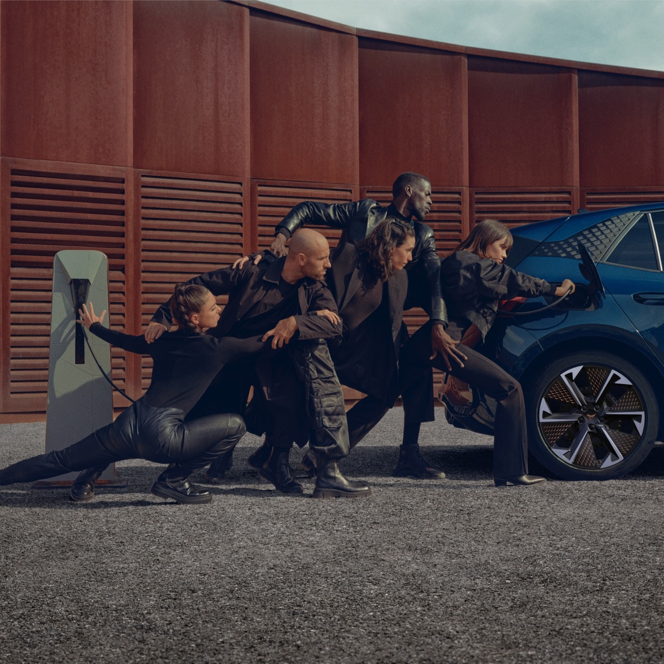 Personas posando con CUPRA Born cargándose en casa