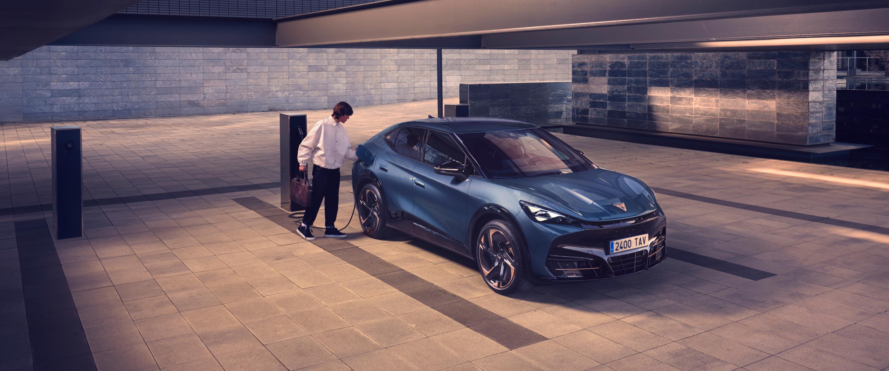 Hombre conectado un CUPRA Tavascan coche eléctrico en punto de caga pública