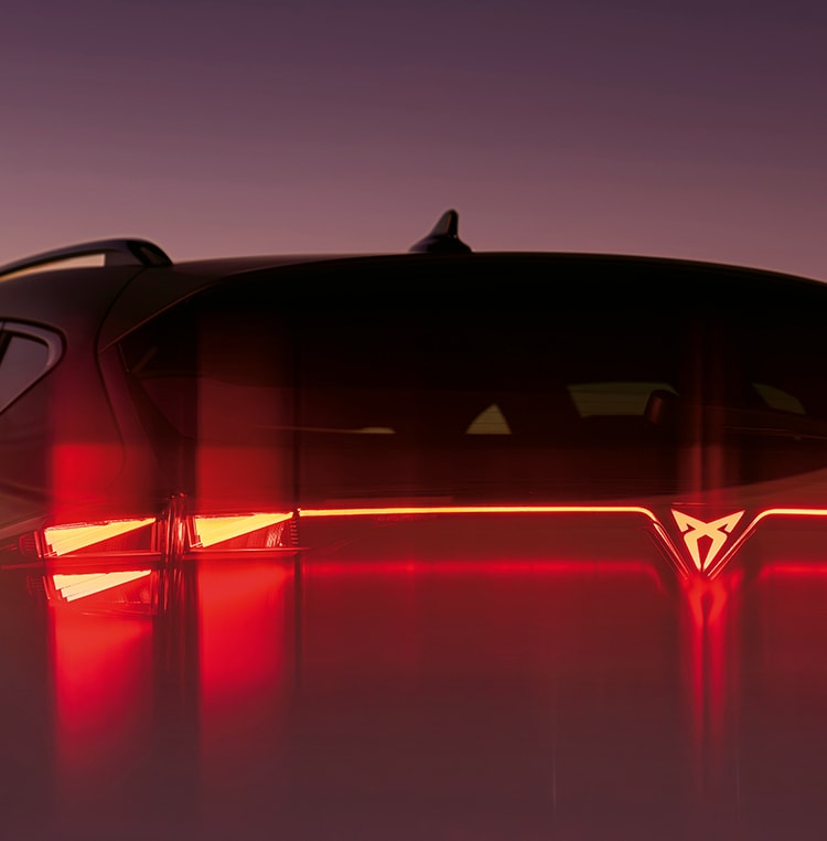 CUPRA Formentor VZ compacto deportivo híbrido enchufable vista trasera con faros LED encendidos.