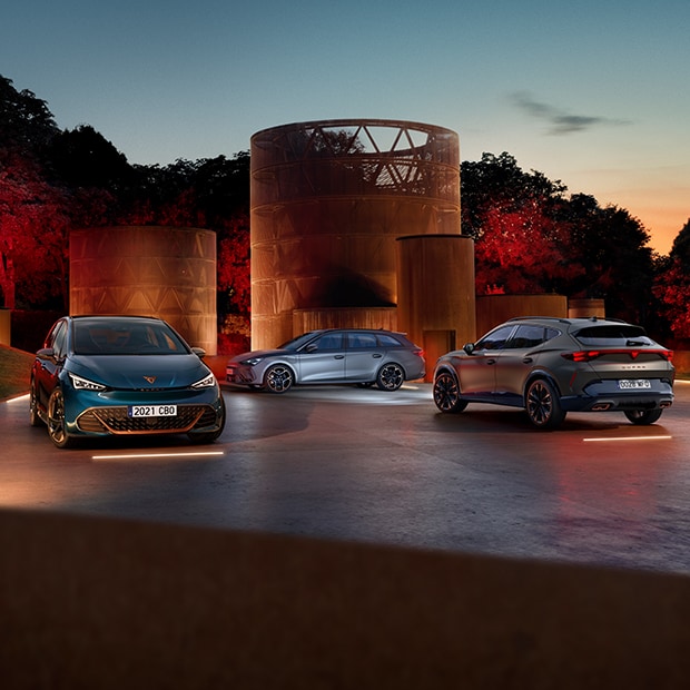 Vista frontal del CUPRA Born, lateral del CUPRA León Sportstourer y trasera del CUPRA Formentor, aparcados en entorno exterior.