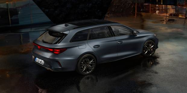 CUPRA León Sporstourer Híbrido Enchufable estacionado en un entorno nocturno con ciudad de fondo