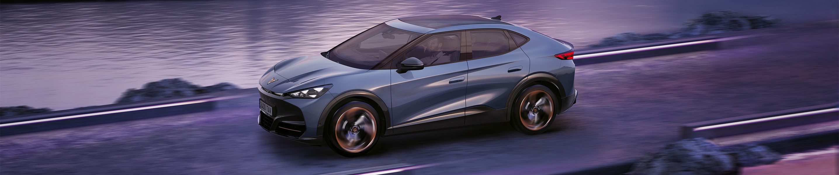 CUPRA Tavascan coupé eléctrico pasando circulando por carretera de costa al amanecer