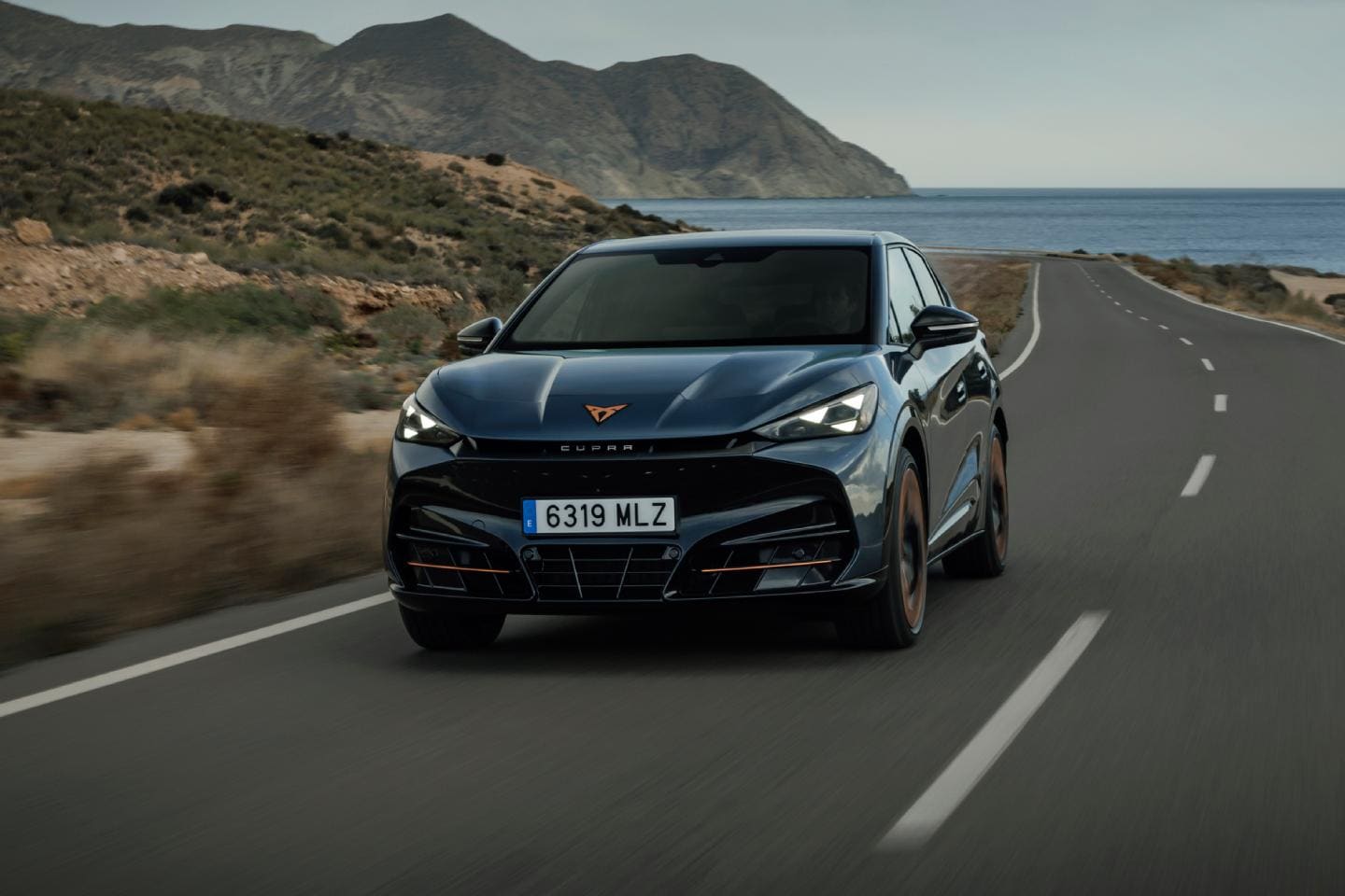 CUPRA Tavascan 100% eléctrico circula por carretera secundaria costera