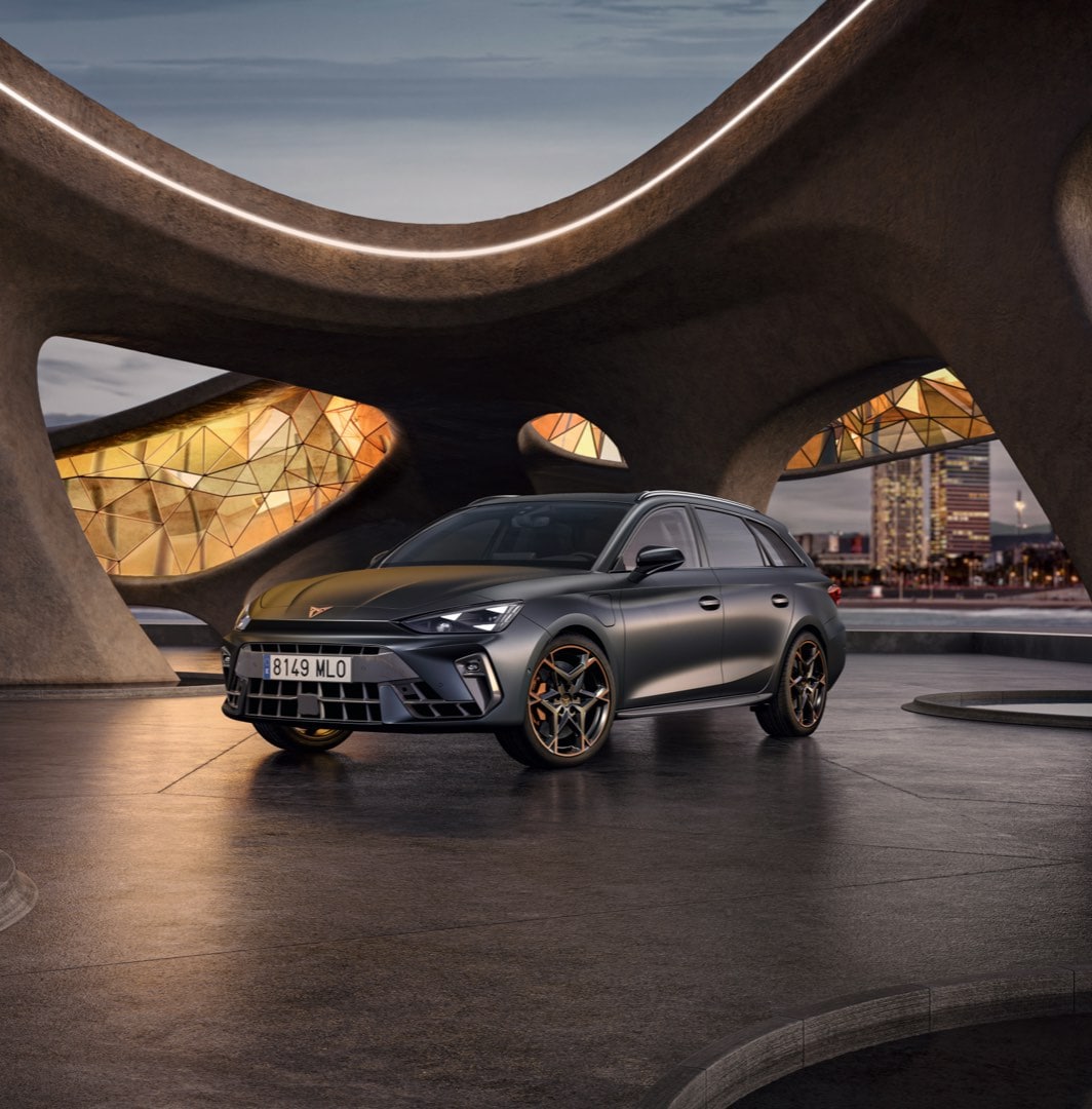 Cupra leon for sale, hatchback in magnetic tech matt grey with 19 inch polar copper wheels and illuminated city background. New car offers available.