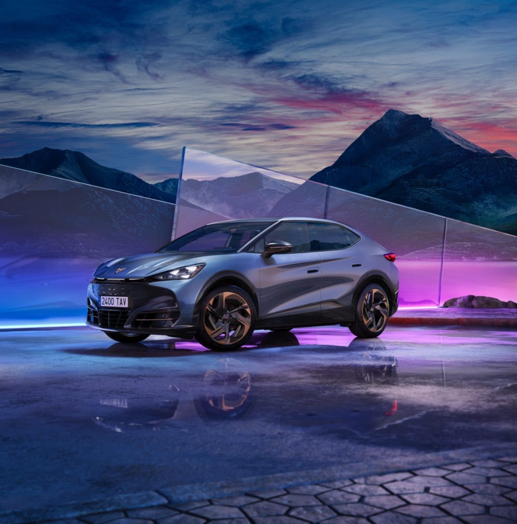 Cupra tavascan electric car offer, suv coupe in tavascan blue colour with 21 inch katla wheels. Glass panel and sky background.