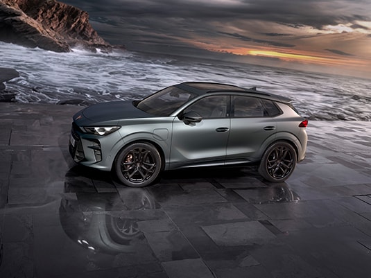 Cupra terramar suv in timanfaya grey, model year 2025, with 19 inch cosmic copper wheels at sunset by the sea. Hybrid suv for sale.