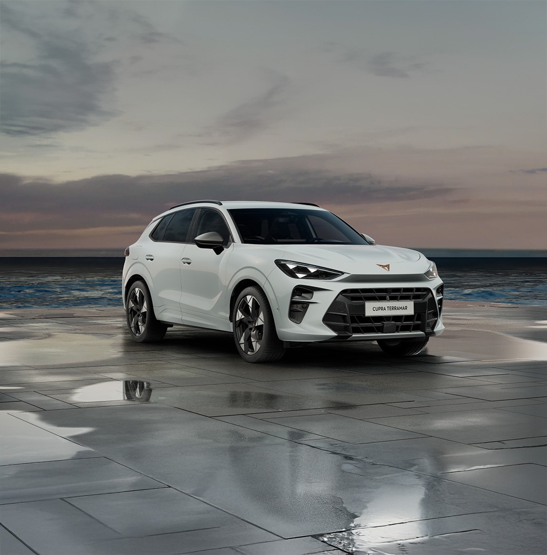 Cupra terramar suv in timanfaya grey, model year 2025, with 19 inch cosmic copper wheels at sunset by the sea. Hybrid suv for sale.