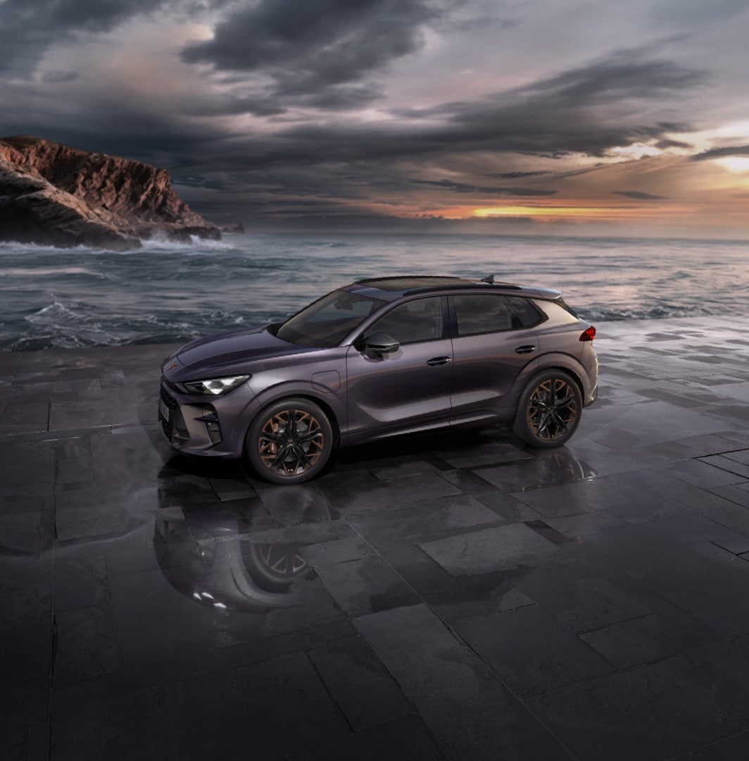 Cupra terramar suv in timanfaya grey, model year 2025, with 19 inch cosmic copper wheels at sunset by the sea. Hybrid suv for sale.