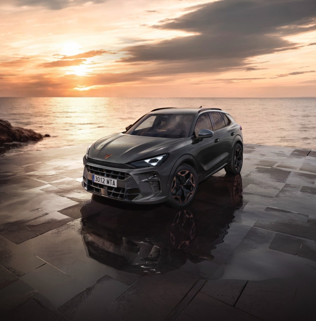 Cupra terramar suv in timanfaya grey, model year 2025, with 19 inch cosmic copper wheels at sunset by the sea. Hybrid suv for sale.