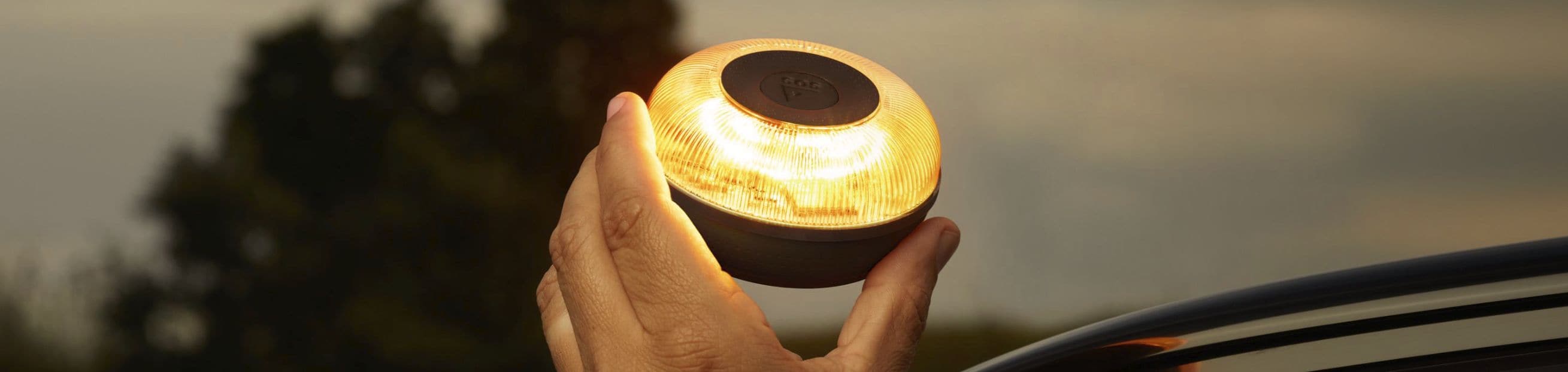 Mano colocando una baliza V16 sobre el techo de su coche CUPRA