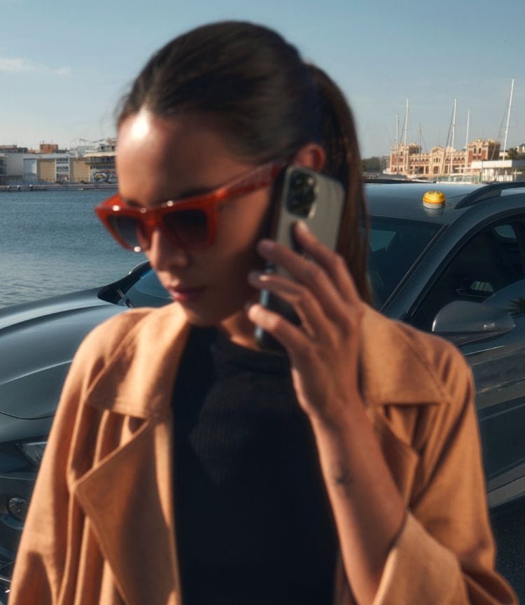 CUPRA Formentor crossover con baliza V16 instalada en el techo, aparcado en un puerto deportivo.