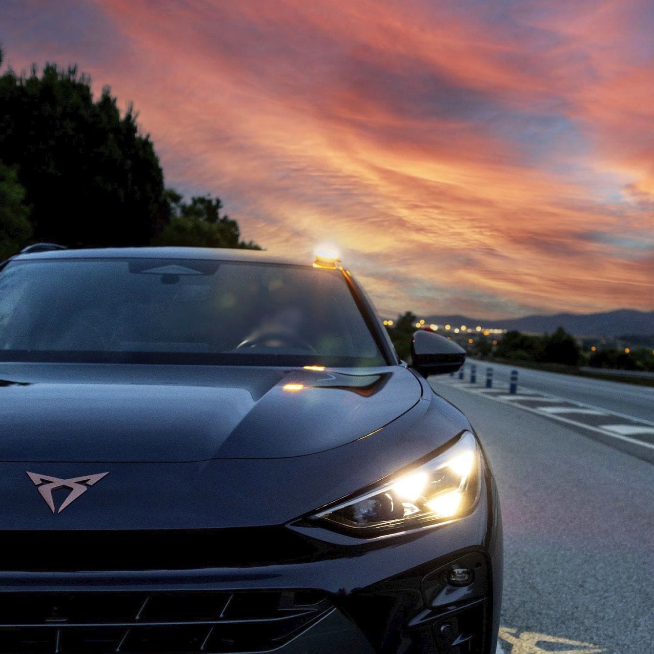 Baliza V16 instalada en techo de CUPRA León estacionado en arcén de carretera