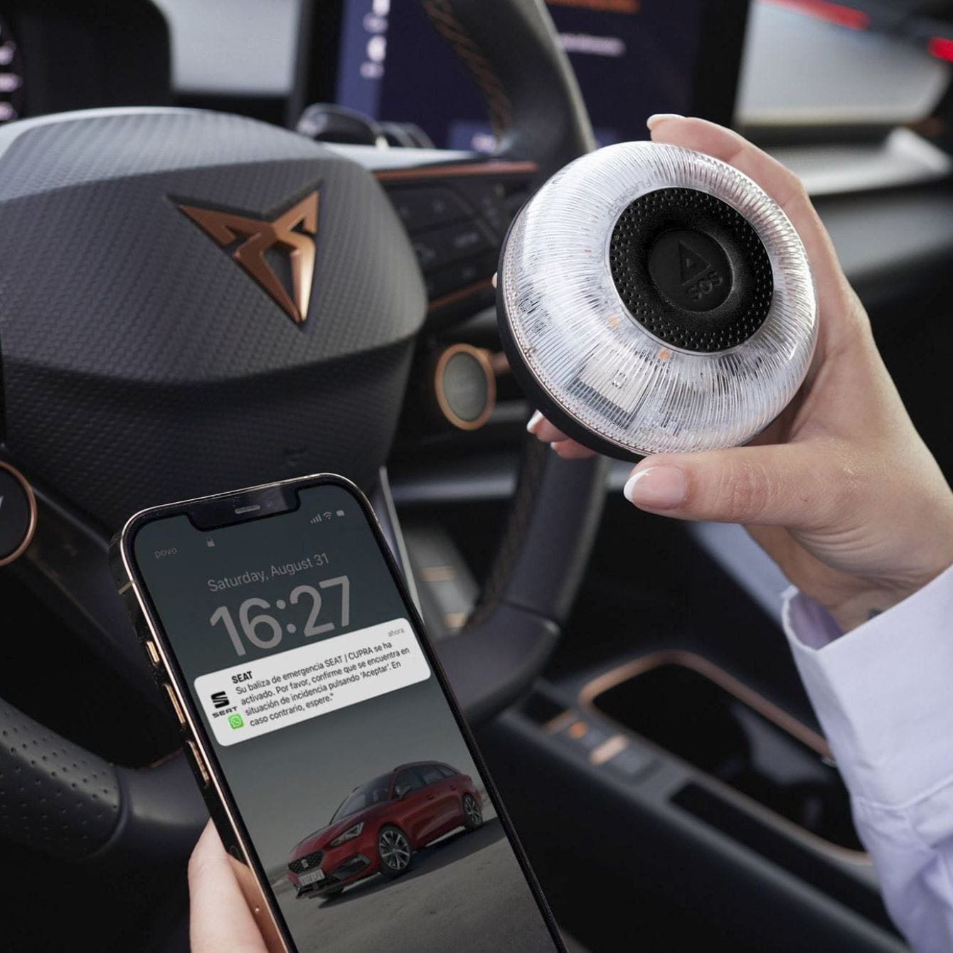 Persona en el interior de CUPRA León está sincronizando su baliza V16 conectada con DGT