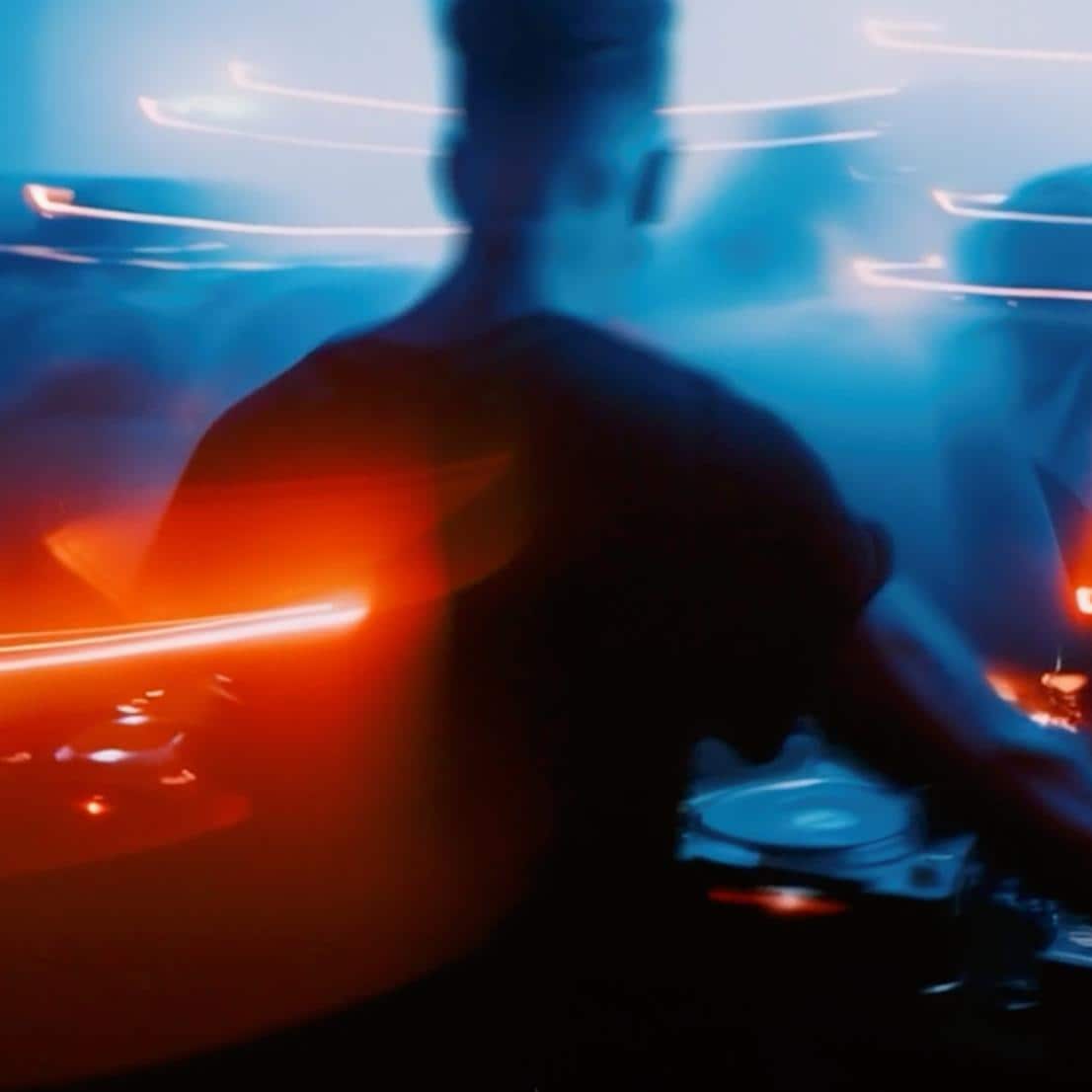 DJ componiendo música rodeado por luces neón de color naranja