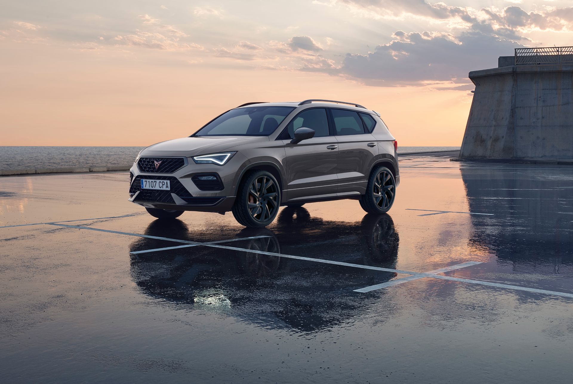 CUPRA Ateca SUV compacto deportivo en color gris graphite sobre pavimento mojado al atardecer