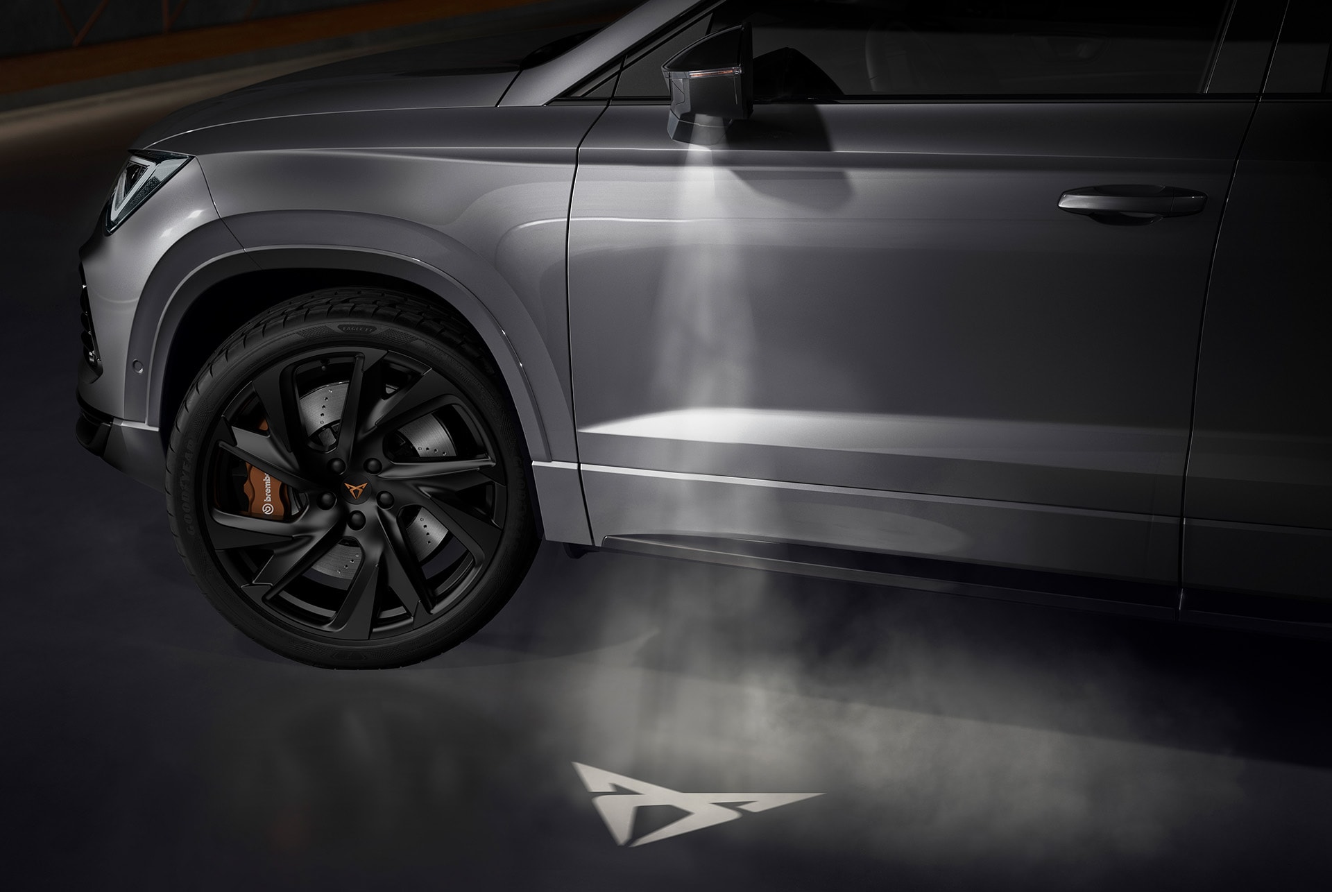 Logotipo de CUPRA proyectado en el suelo desde el CUPRA Ateca, representando la conexión con la Tribu CUPRA.