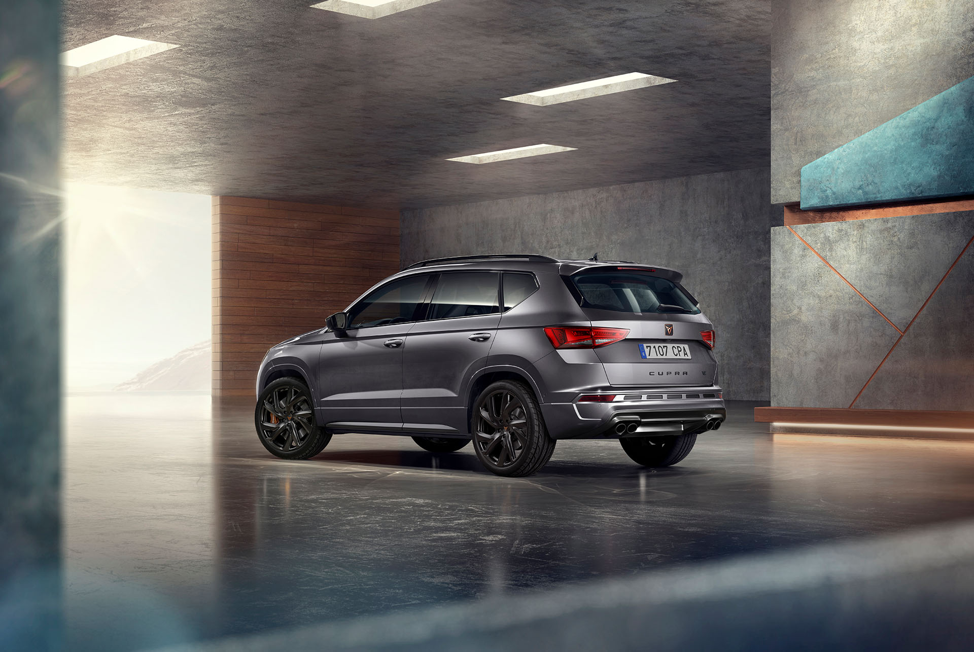 Un CUPRA Ateca SUV gris sobre fondo blanco. El coche presenta una atrevida parrilla delantera, faros LED y llantas de aleación con detalles en cobre, que resaltan su diseño de coche deportivo.