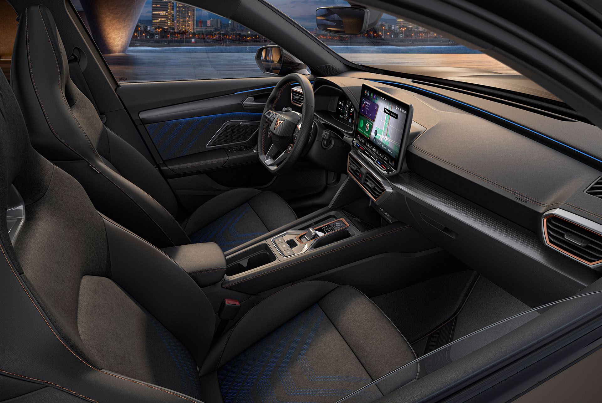 Nuevo diseño interior dinámico CUPRA Formentor 2025, asientos negros y azules con costuras geométricas, salpicadero Advanced con pantalla táctil multimedia e iluminación ambiental, con el telón de fondo del horizonte de una ciudad por la noche.