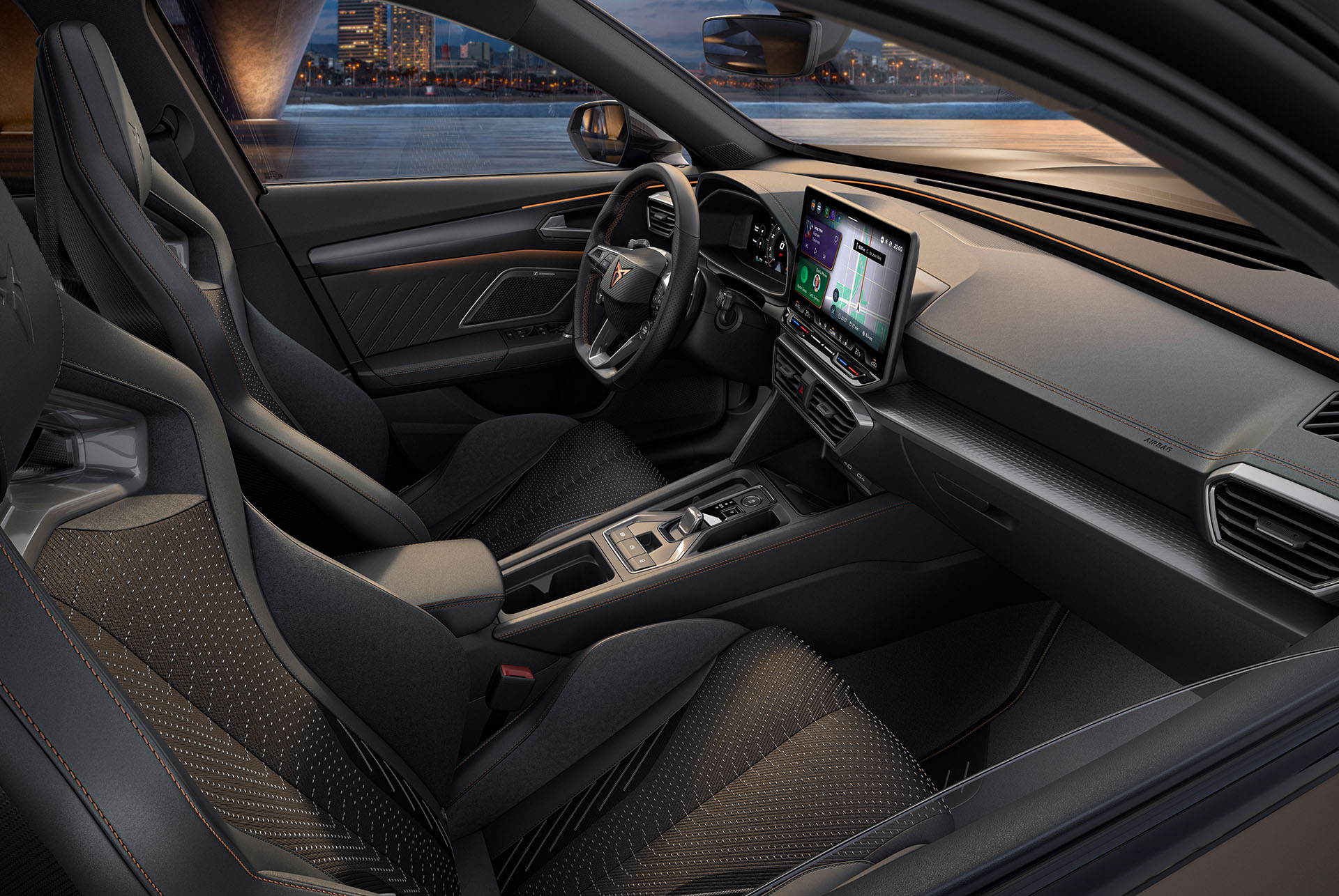 Vista interior del nuevo CUPRA Formentor 2025 con asientos deportivos, costuras detalladas, volante multifunción, grandes pantallas de Infotainment y un salpicadero de diseño elegante. Desde el vehículo se ve un paisaje urbano al anochecer a través del parabrisas.