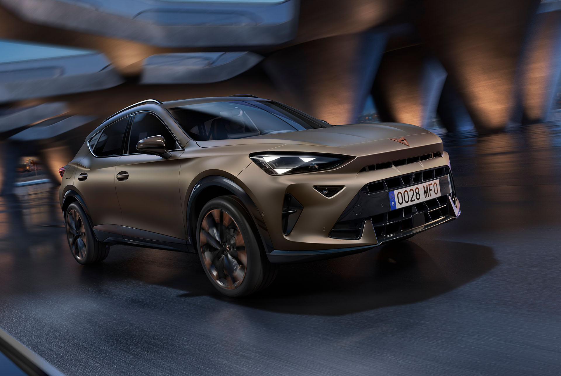 Nuevo CUPRA Formentor 2025 en Century Bronze mate, en movimiento con divisor del par motor. Skyline y arquitectura difuminados.