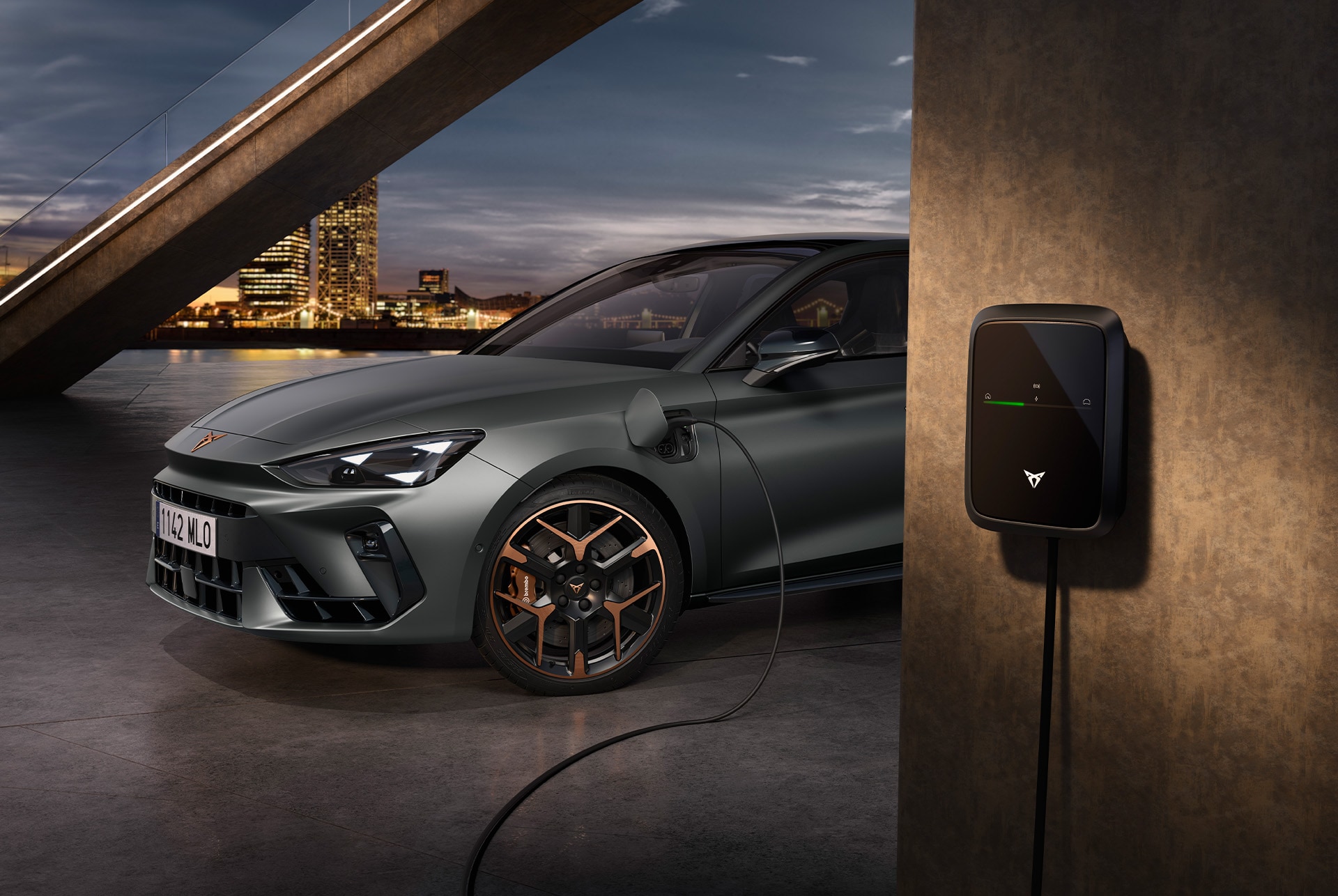 side, half view shot of the cupra leon sportstourer vz e-hybrid plugged in a urban backdrop.