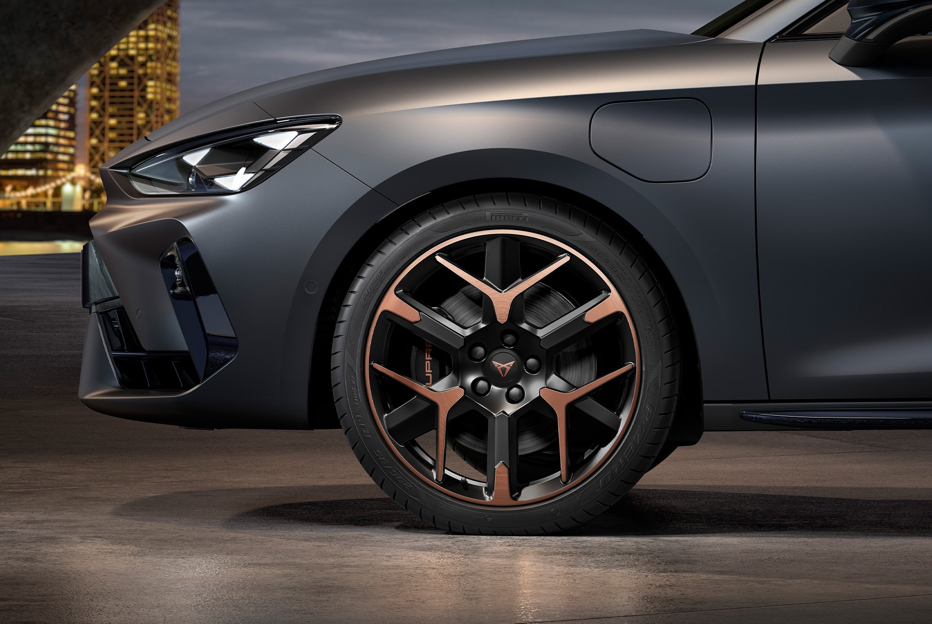 vista lateral delantera de la llanta de aleación forjada izquierda en cobre y negro para el nuevo CUPRA León Sportstourer 2025, neumáticos, faros característicos y carrocería gris
