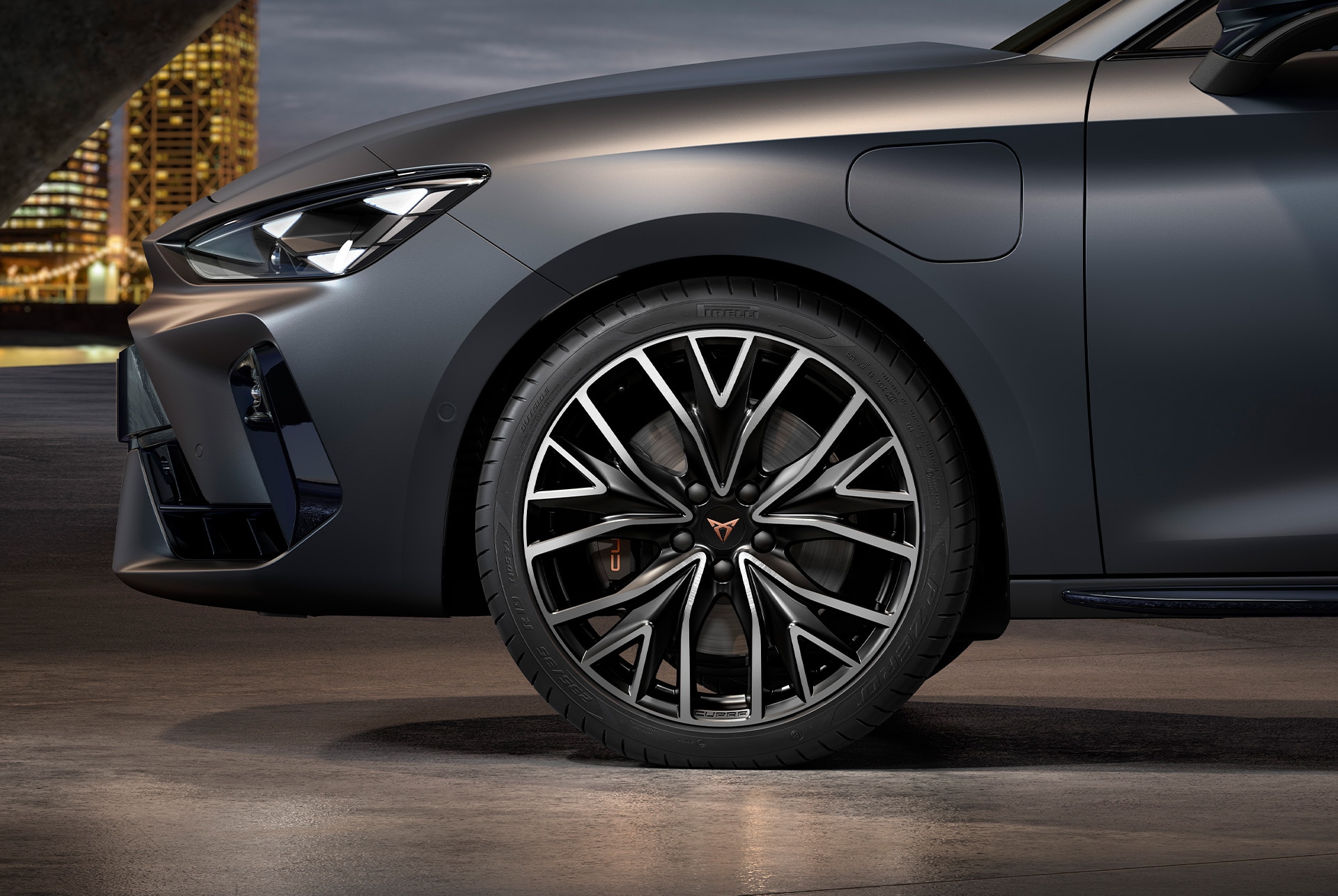 vista lateral delantera de las llantas de aleación mecanizadas izquierdas en plateado y negro para el nuevo CUPRA León Sportstourer 2025, neumáticos, faros característicos y carrocería gris