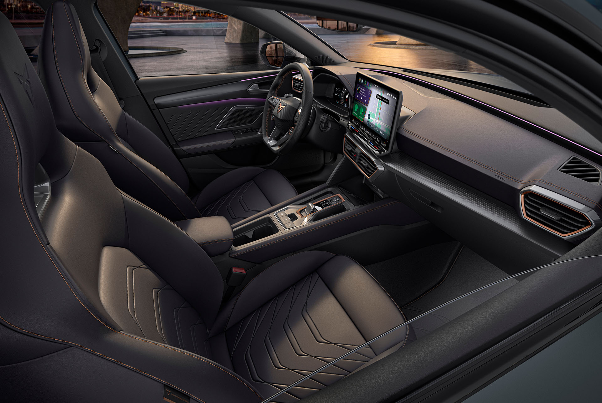 Interior del nuevo CUPRA León Sportstourer 2025 gris, asientos del conductor y el copiloto, sistema de Infotainment, volante cupra, asientos tipo bucket, al atardecer.