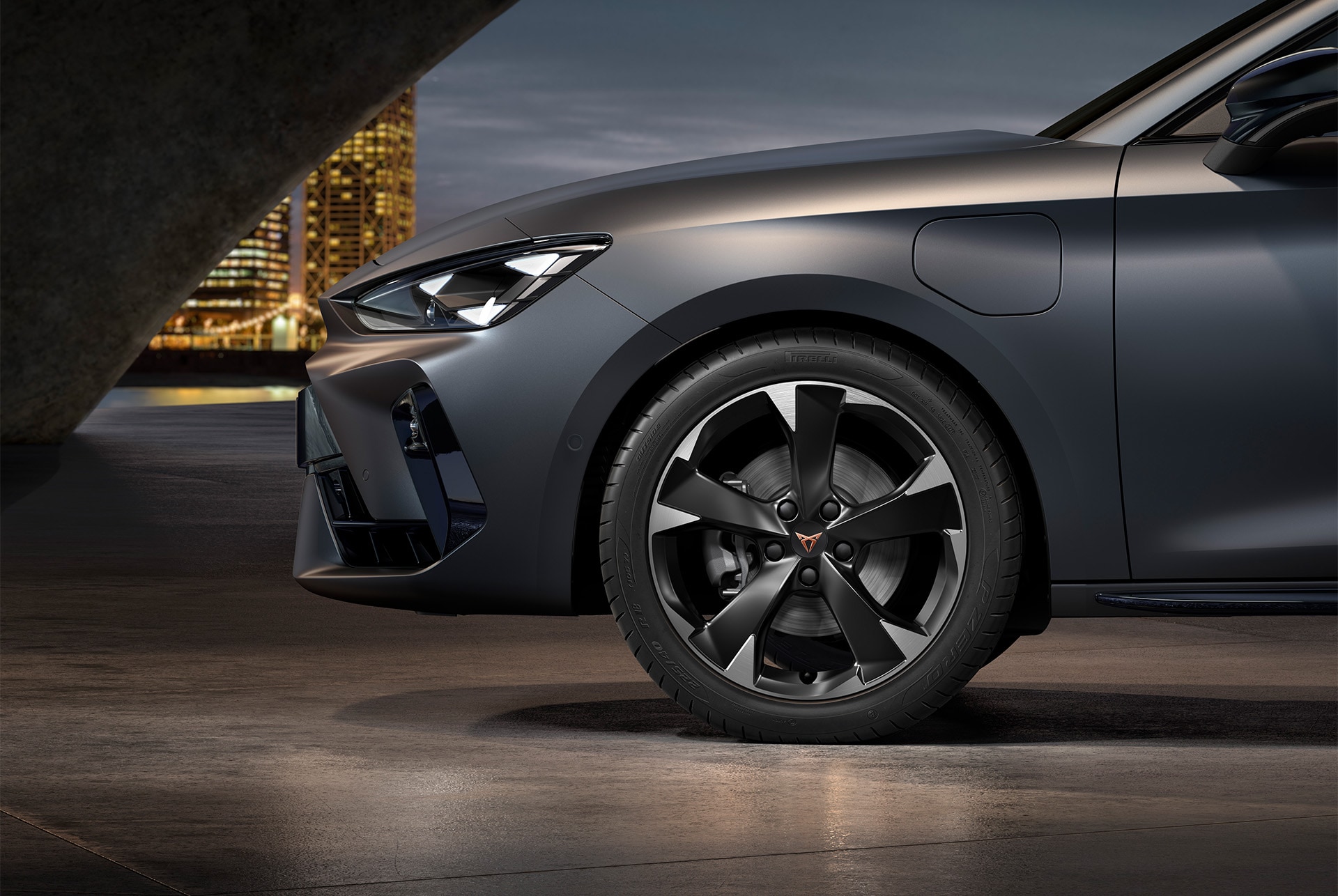 vista frontal lateral de las llantas izquierdas de aleación mecanizadas Silver Garbi para el nuevo CUPRA León 2025, neumáticos, faros característicos y carrocería gris mate