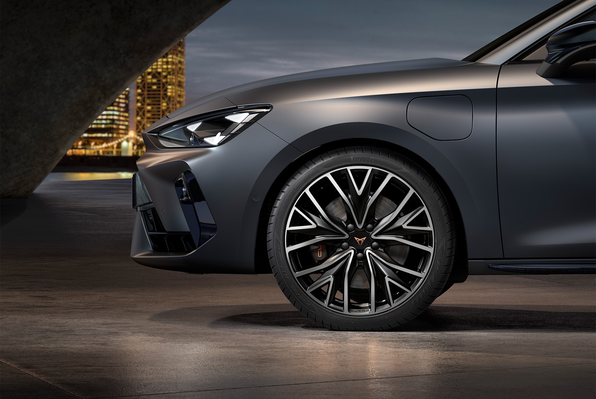 vista lateral delantera de las llantas de aleación mecanizadas izquierdas en plateado y negro para el nuevo CUPRA León 2025, neumáticos, faros característicos y carrocería gris