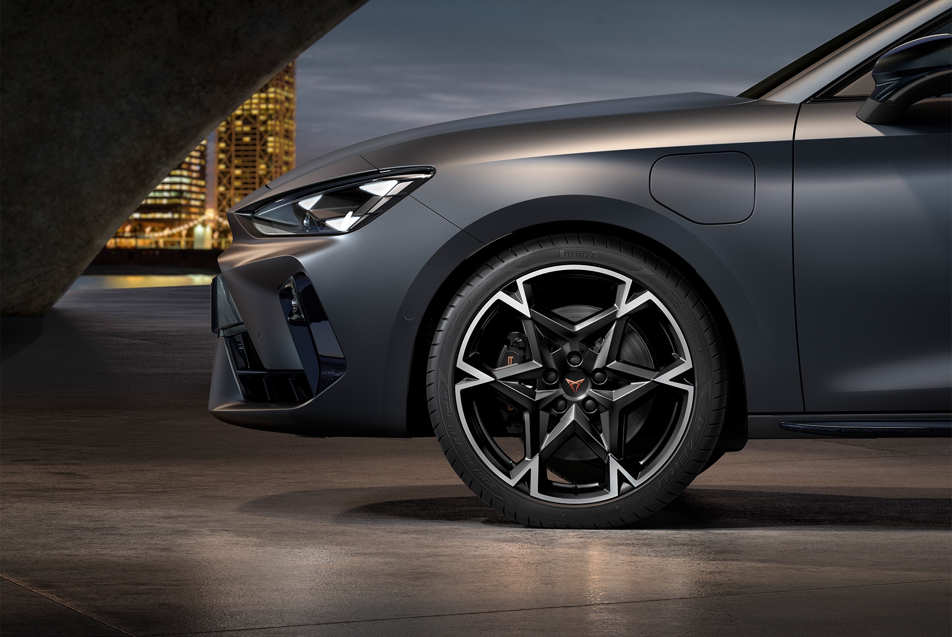 vista lateral delantera de la llanta de aleación mecanizada polar izquierda en negro y plateado para el nuevo CUPRA León 2025, neumáticos, faros característicos y carrocería gris