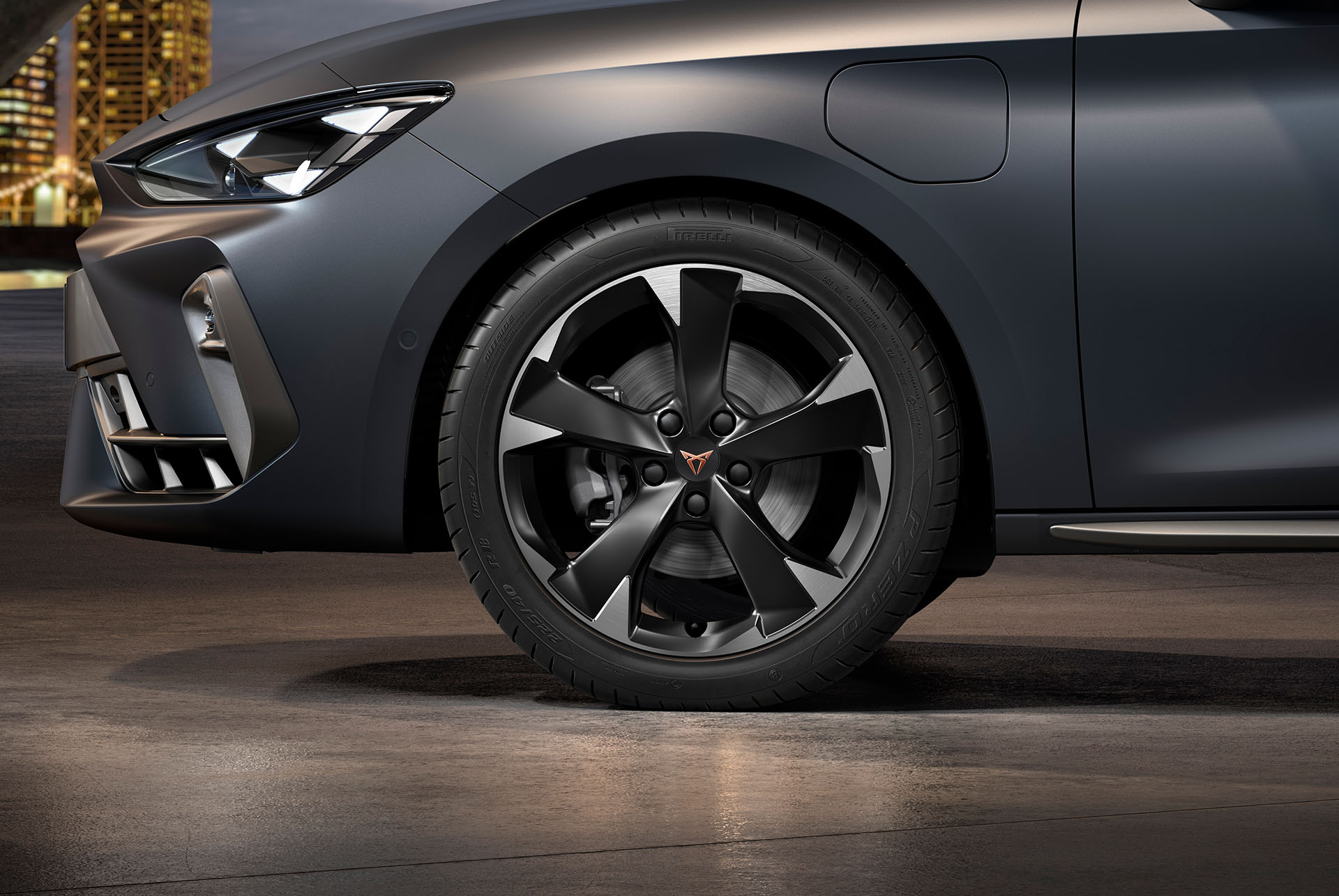 vista frontal lateral de las llantas izquierdas de aleación mecanizadas Silver Garbi para el nuevo CUPRA León 2025, neumáticos, faros característicos y carrocería gris mate
