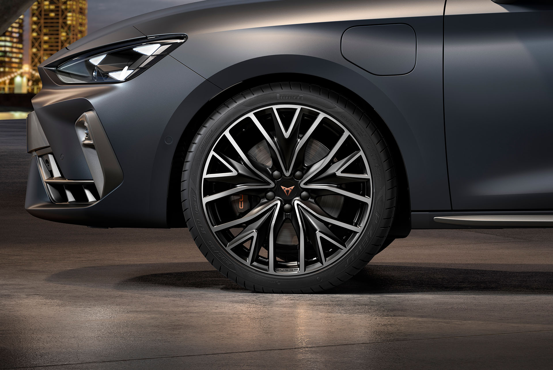 vista lateral delantera de las llantas de aleación mecanizadas izquierdas en plateado y negro para el nuevo CUPRA León 2025, neumáticos, faros característicos y carrocería gris