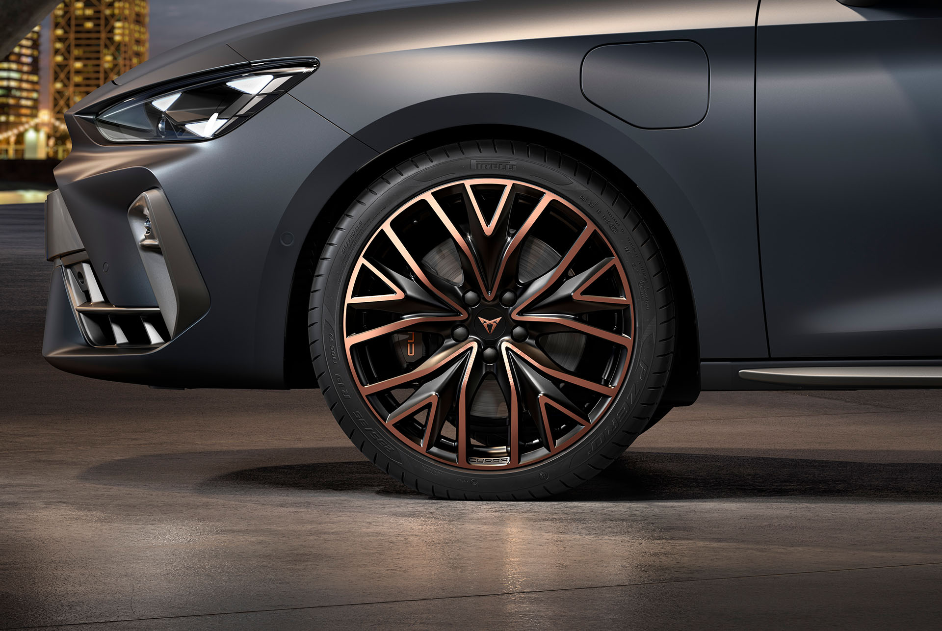 vista lateral delantera de las llantas de aleación mecanizadas izquierdas en plateado y negro para el nuevo CUPRA León 2025, neumáticos, faros característicos y carrocería gris