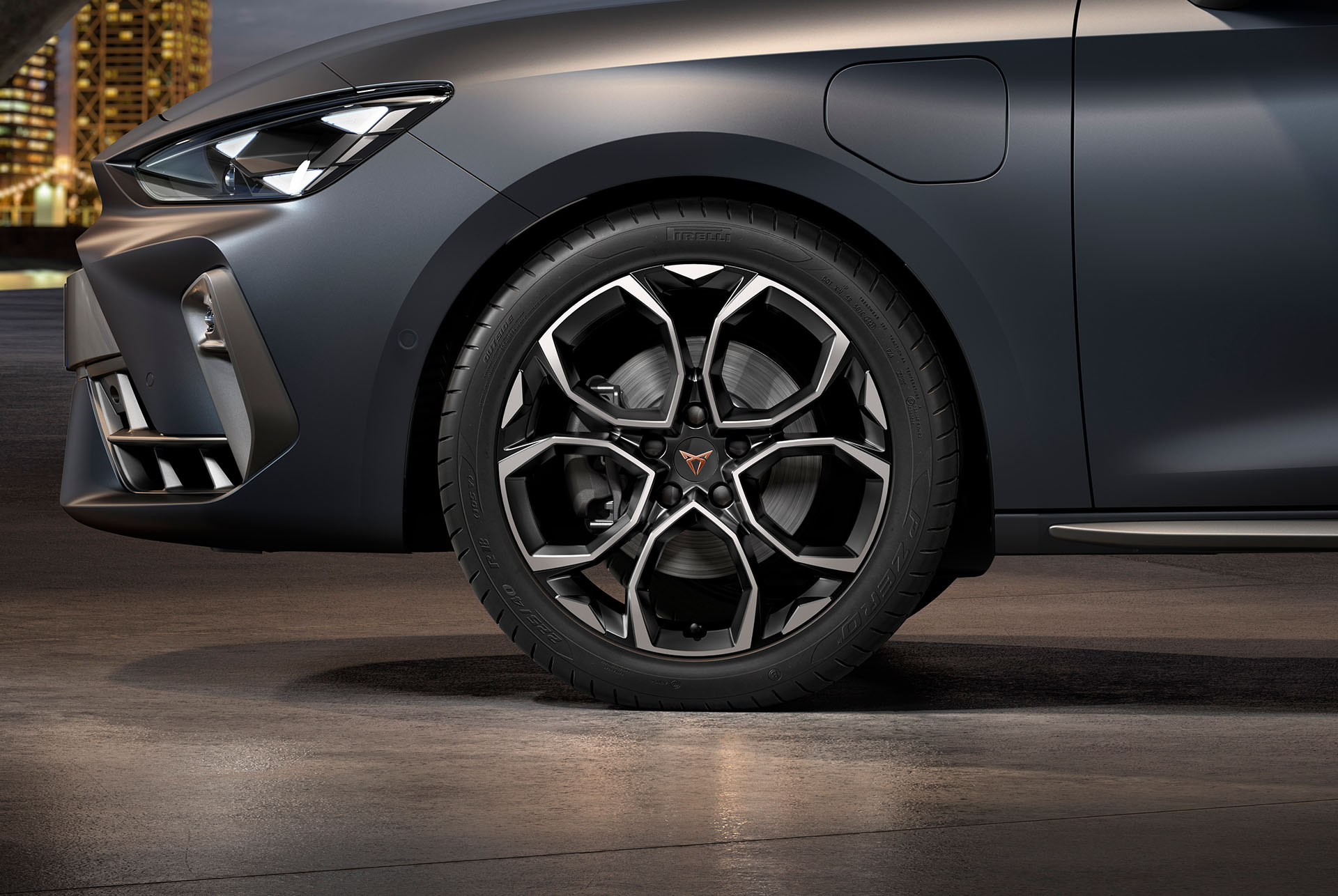 vista frontal lateral de las llantas izquierdas de aleación mecanizadas Windstorm en plateado y negro para el nuevo CUPRA León 2025, neumáticos, faros característicos y carrocería gris