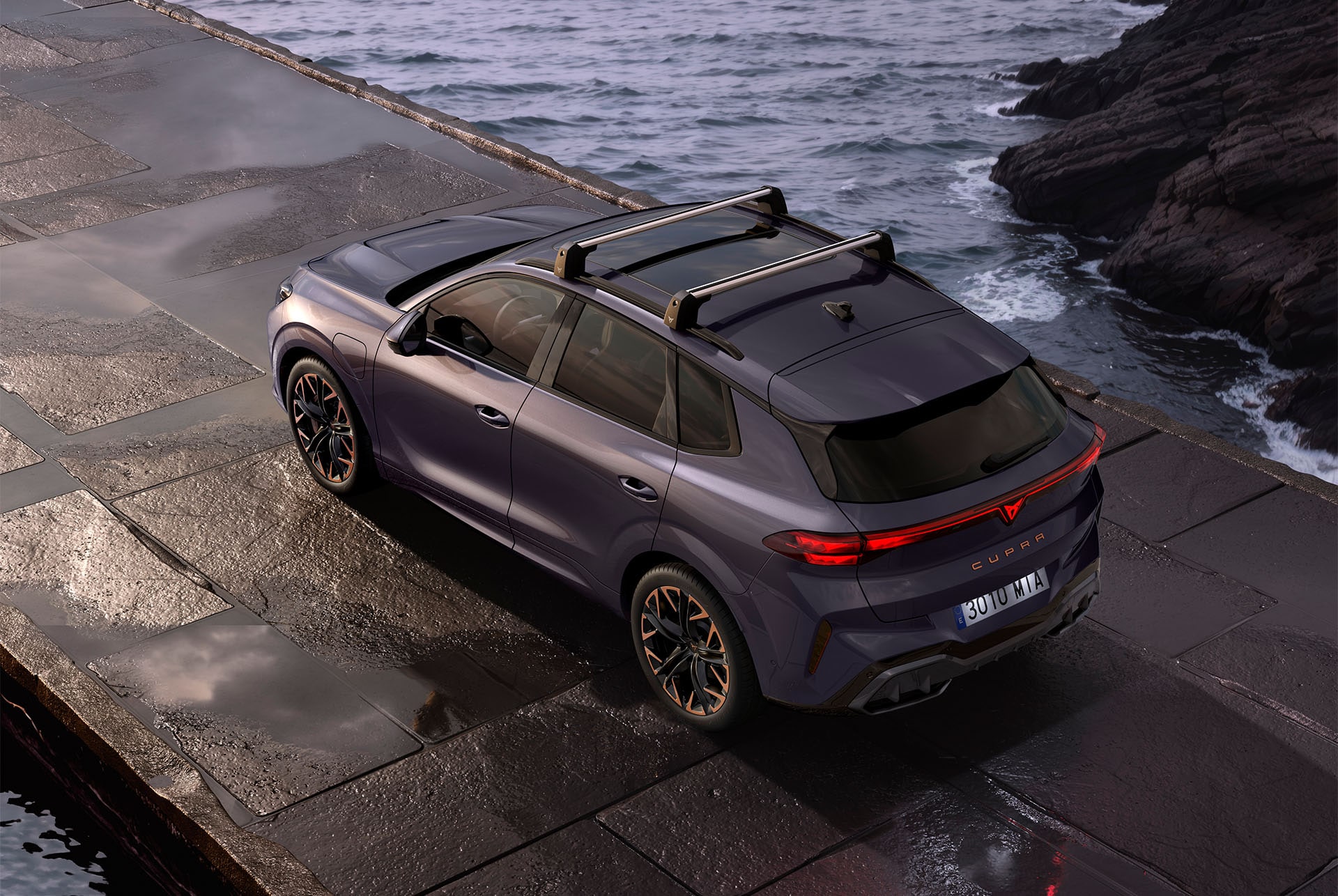 CUPRA Terramar con barras de techo acopladas, aparcado junto a la costa. Las barras de techo ofrecen una solución robusta para transportar objetos grandes, como bicicletas y esquís.