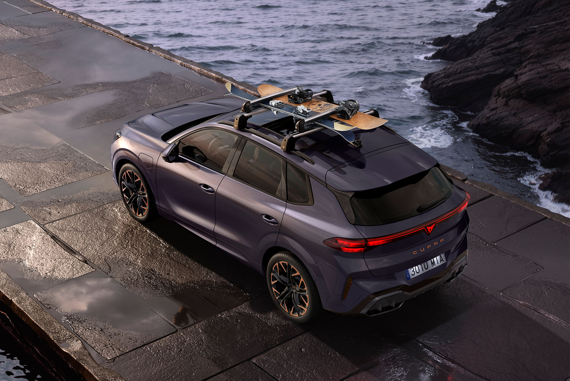 CUPRA Terramar con portaesquís. El SUV está aparcado en una carretera costera, preparándose para una aventura invernal, mostrando la versatilidad del vehículo y el sistema portaesquís de fácil instalación.