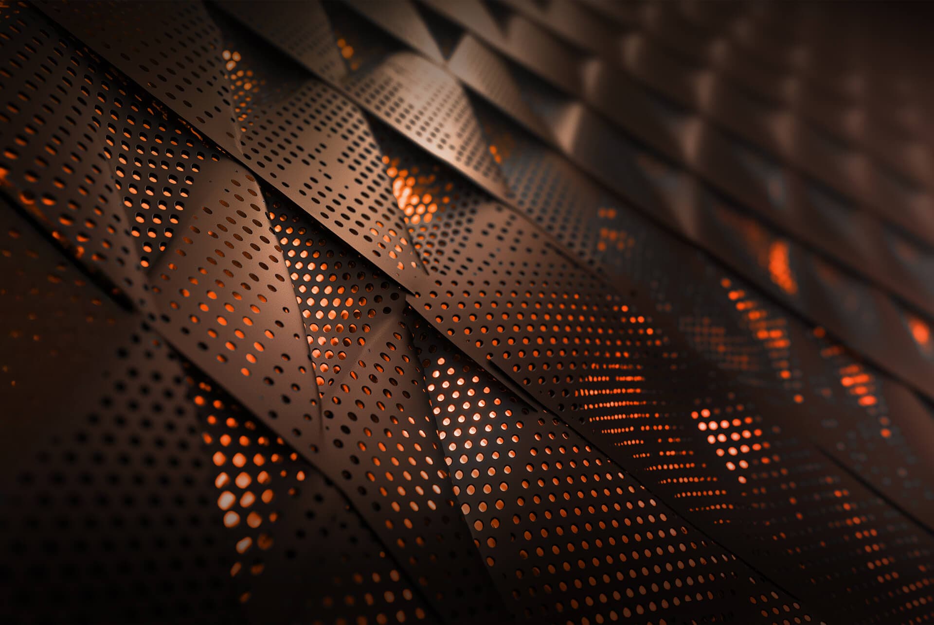 A close-up photo of perforated metal panels with orange light glowing through the holes.