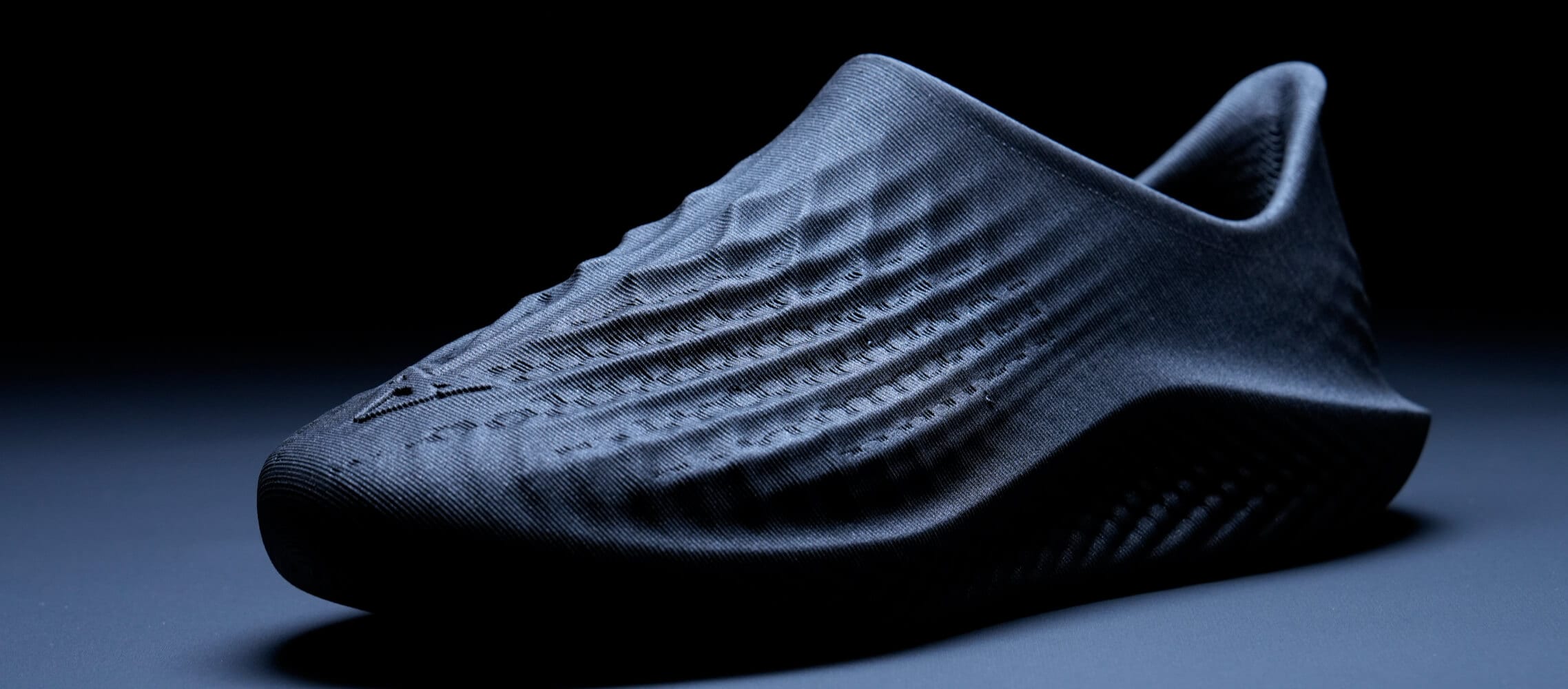 Primer plano de un zapato oscuro y con textura, donde se da protagonismo a la textura y la forma. Primer plano de un zapato oscuro y con textura, donde se da protagonismo a la textura y la forma.