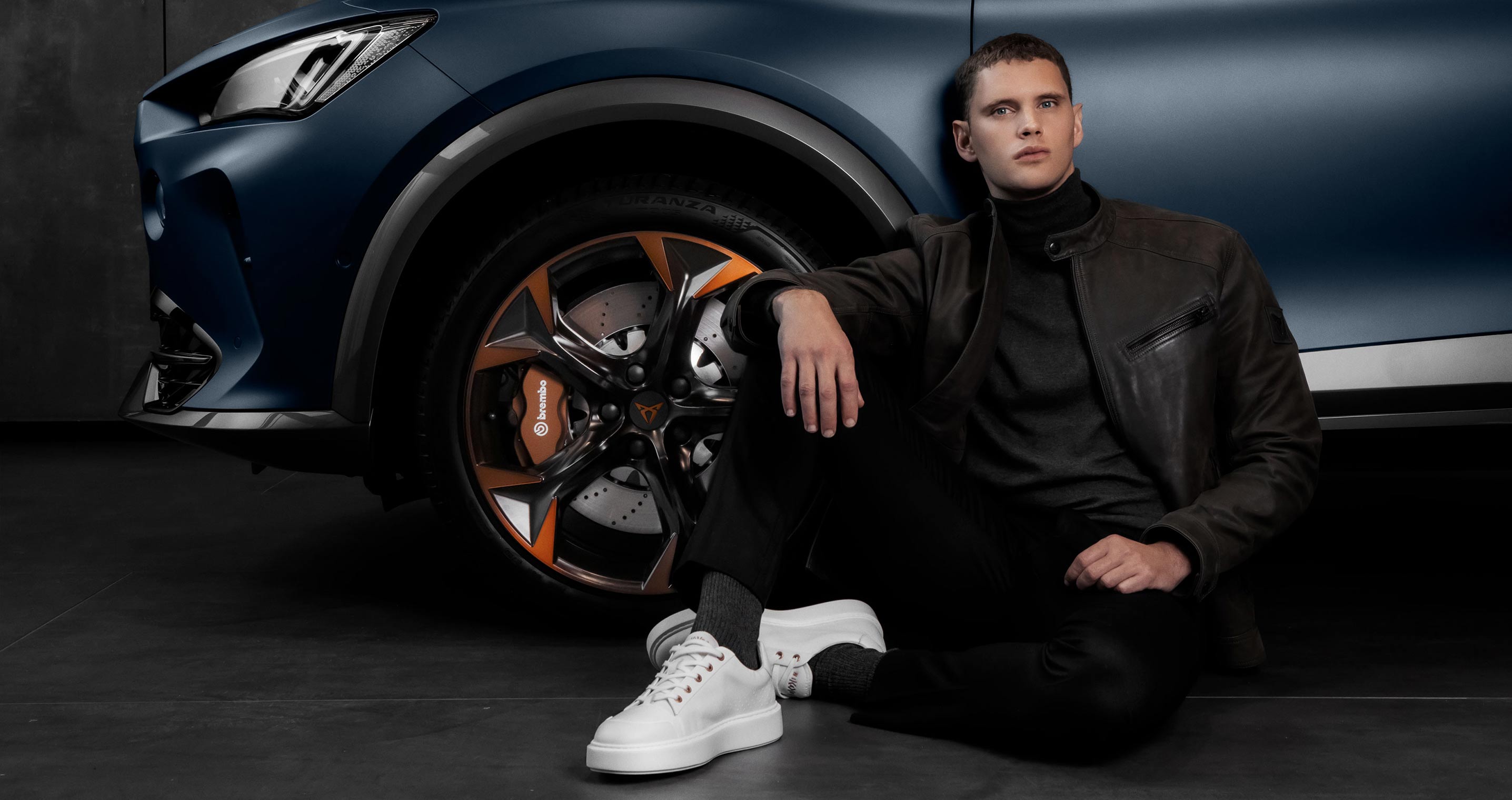 model wearing mikakus x cupra shoe in blue next to a car