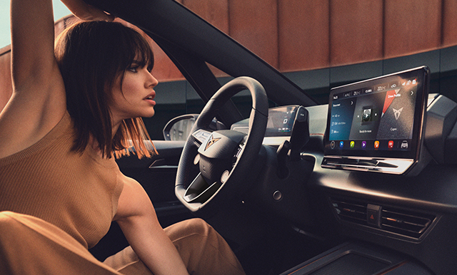 Mujer viendo las actualizaciones inalámbricas del CUPRA en el dispositivo de Infotainment de su coche.