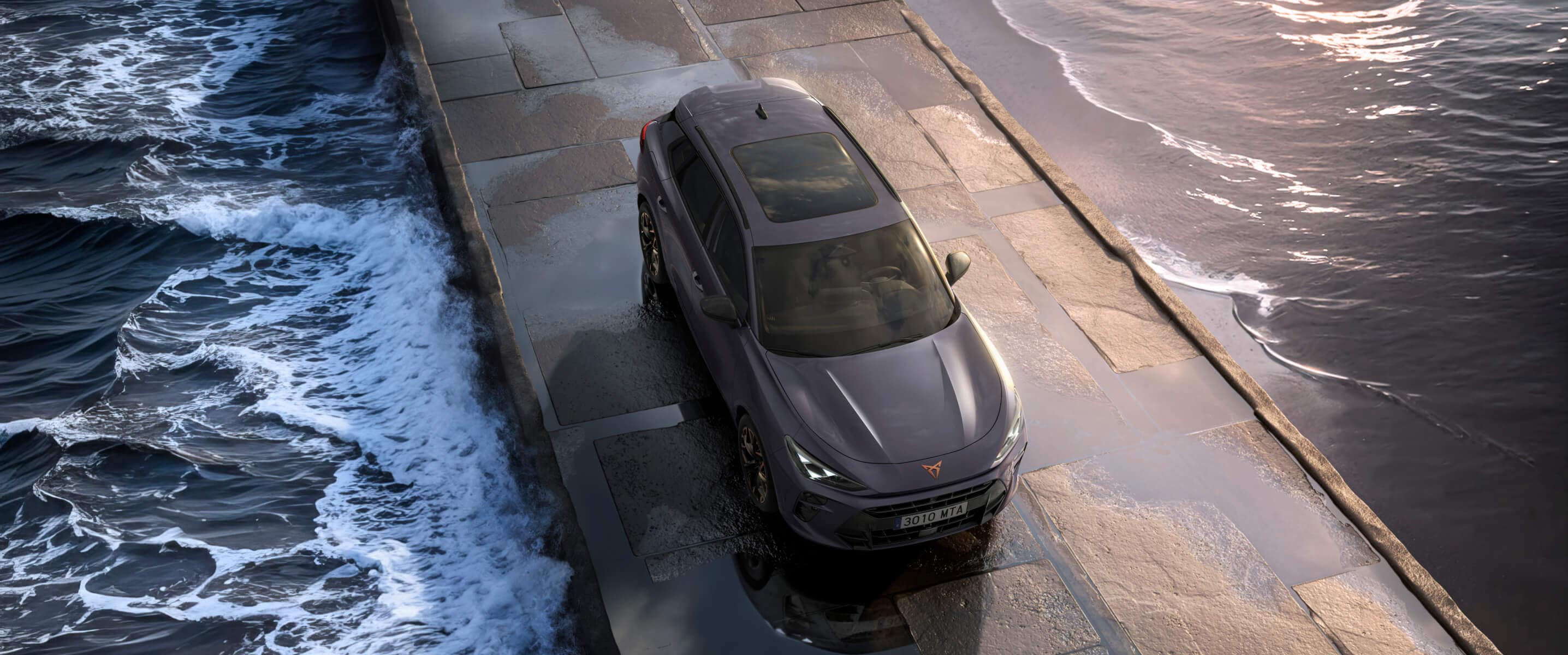 El SUV híbrido CUPRATerramar 2024 sobre un pavimento mojado junto al mar, con faros elegantes, llantas de aleación modernas y un diseño frontal inspirado en un tiburón